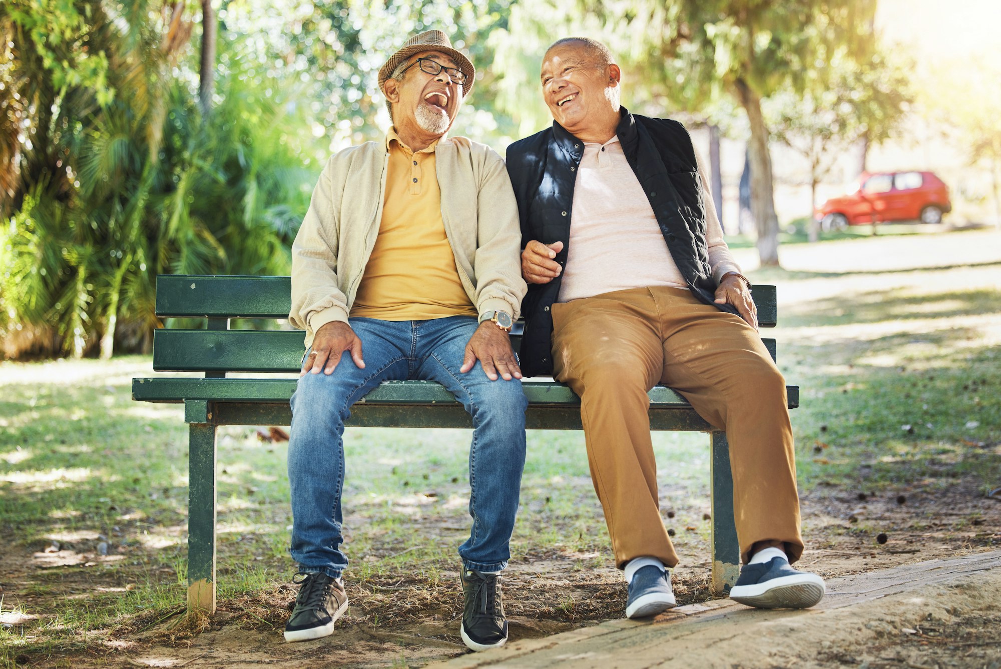 Elderly friends, happy and men on park bench, talking and bonding outdoor to relax in retirement. F