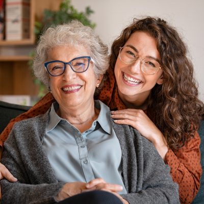 happy senior with younger woman under 24 hour care