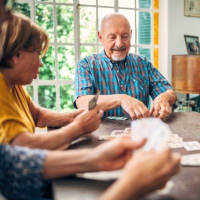 senior friends enjoying cards in game room